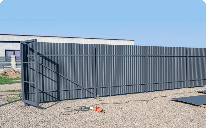Gray metal fence with gate under blue sky