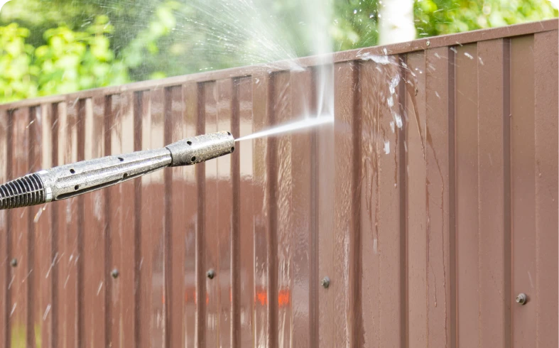 Power washing removes dirt from fence