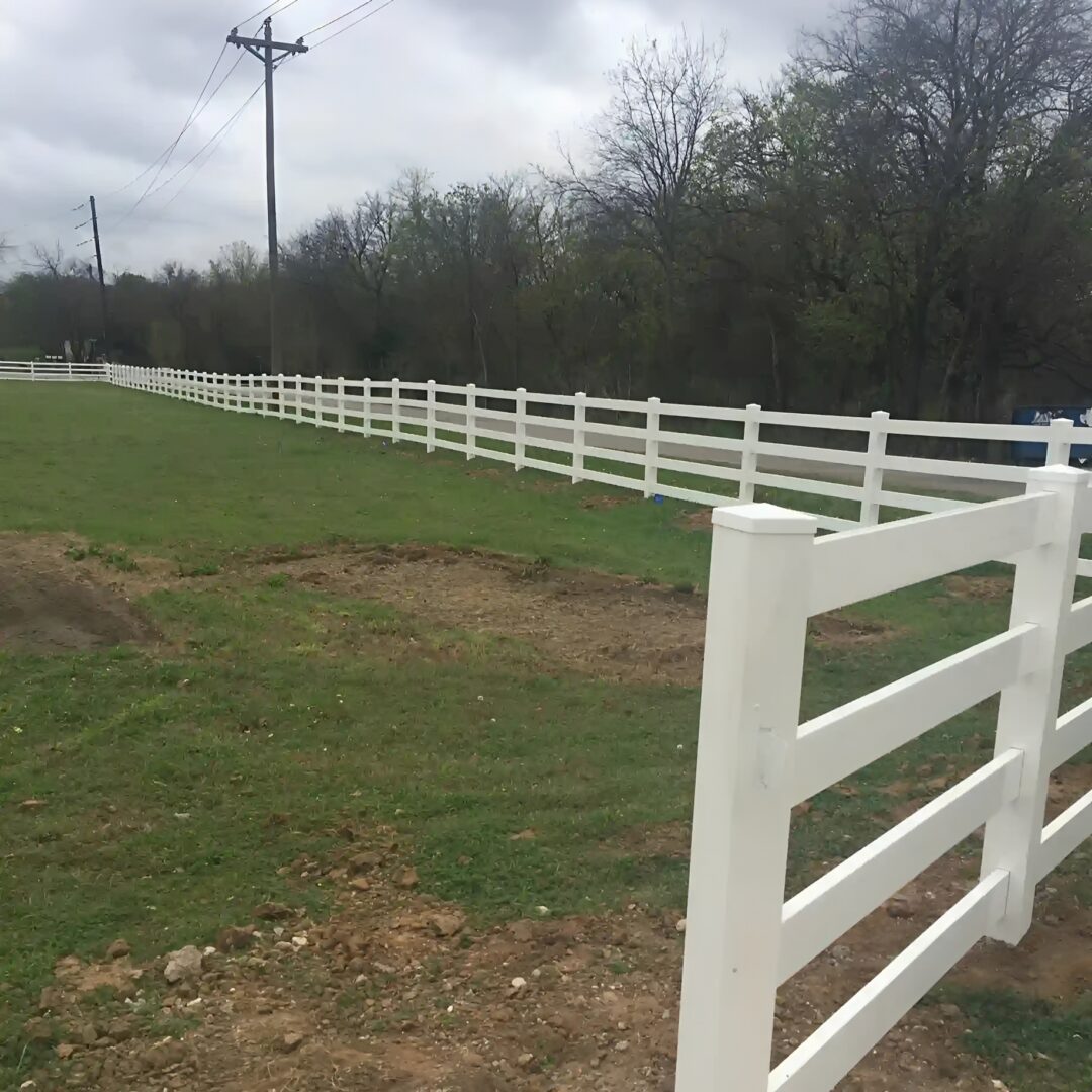 White fence along green field