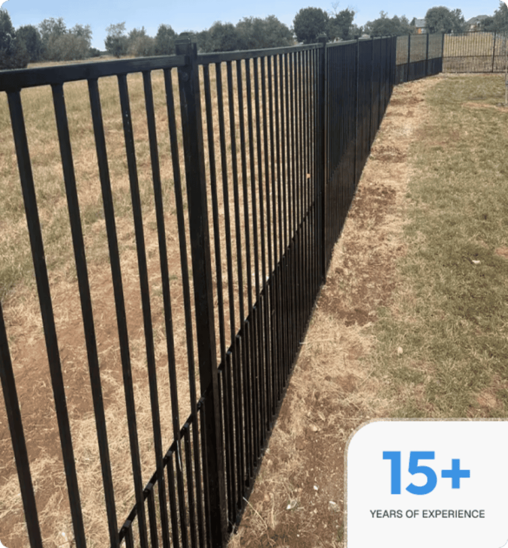 Metal fence extending across dry grass