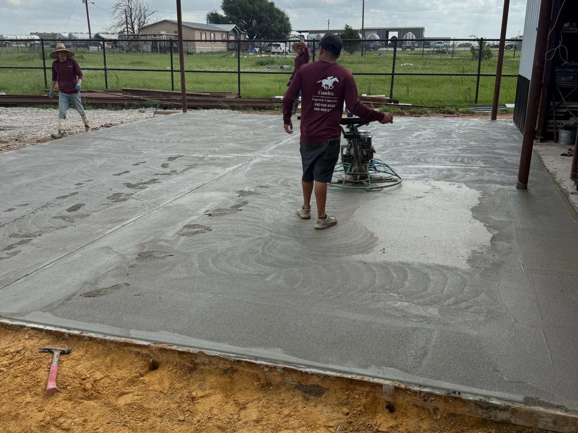 Two men working on a concrete slab in a construction site